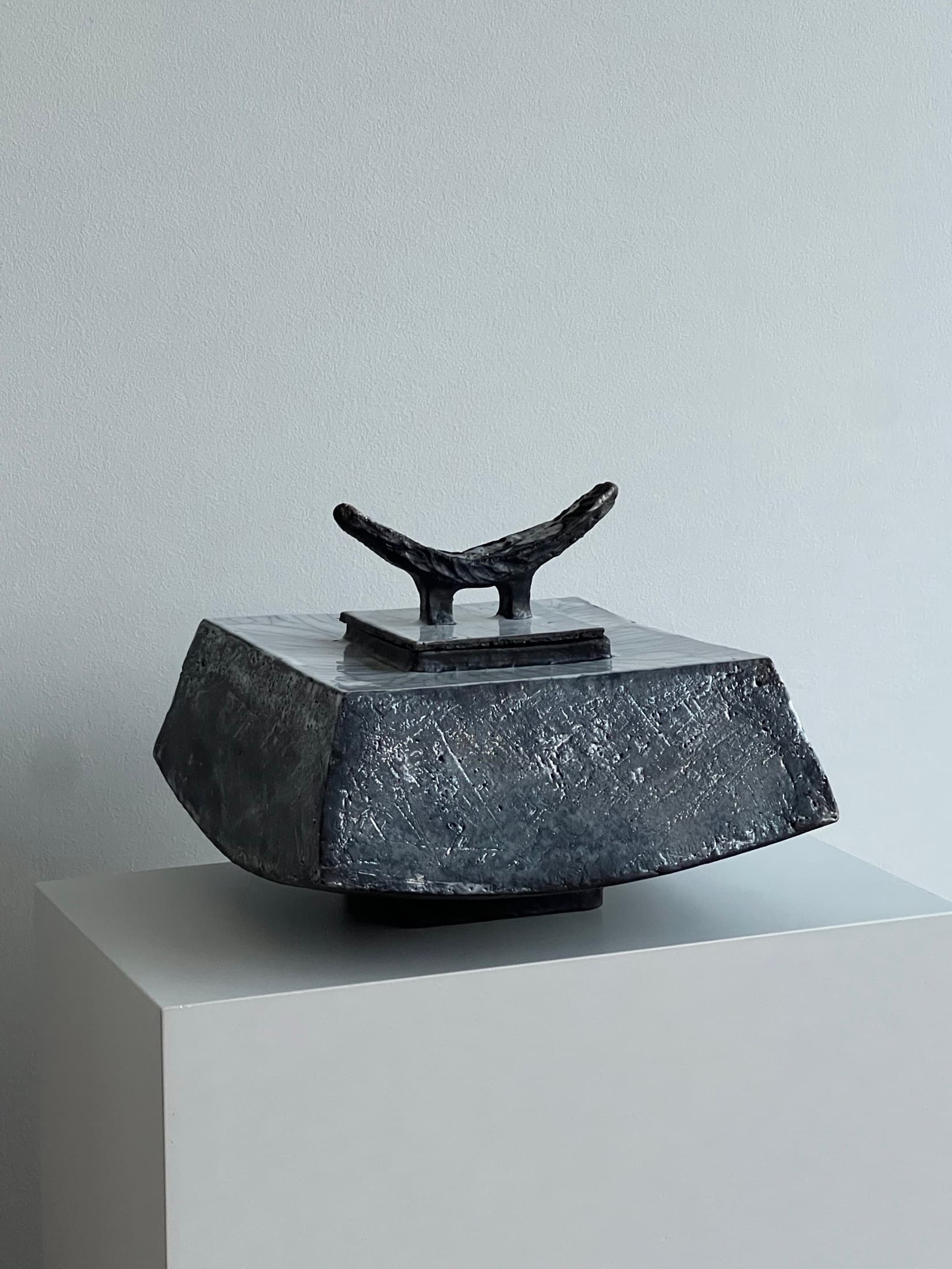 Small lidded object with a horn-shaped handle in black