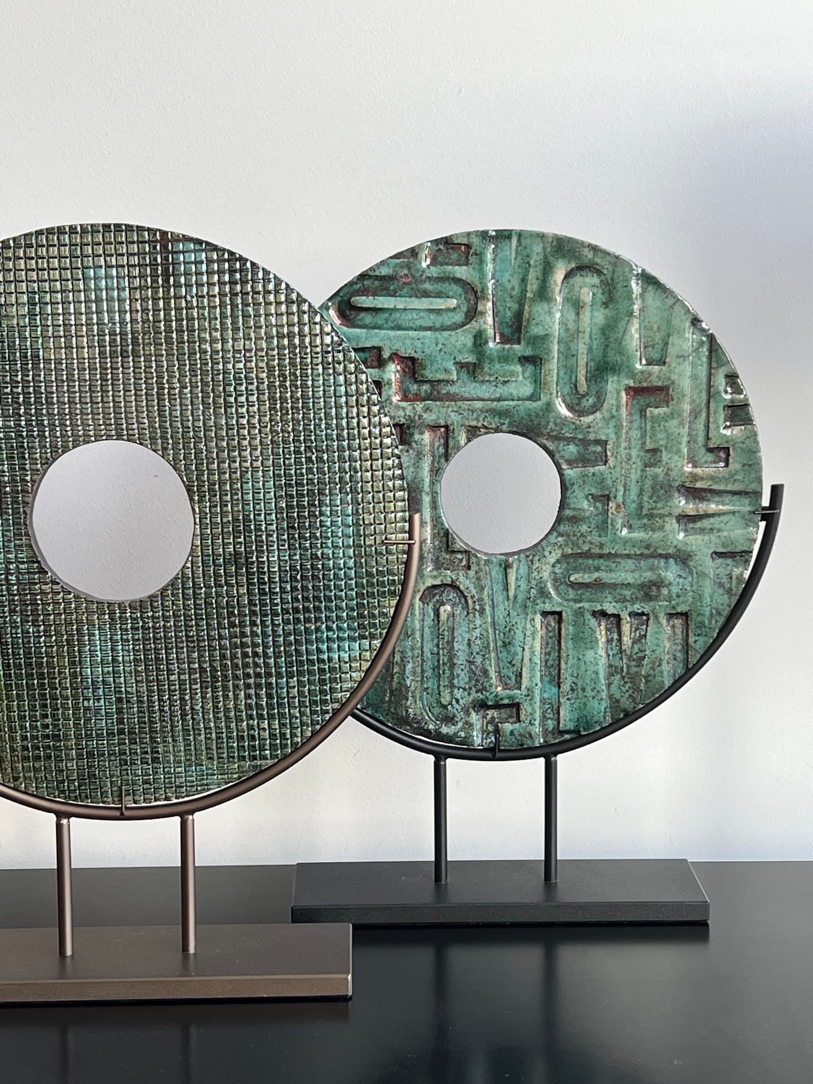 Two discs with mosaic and lettering relief in green