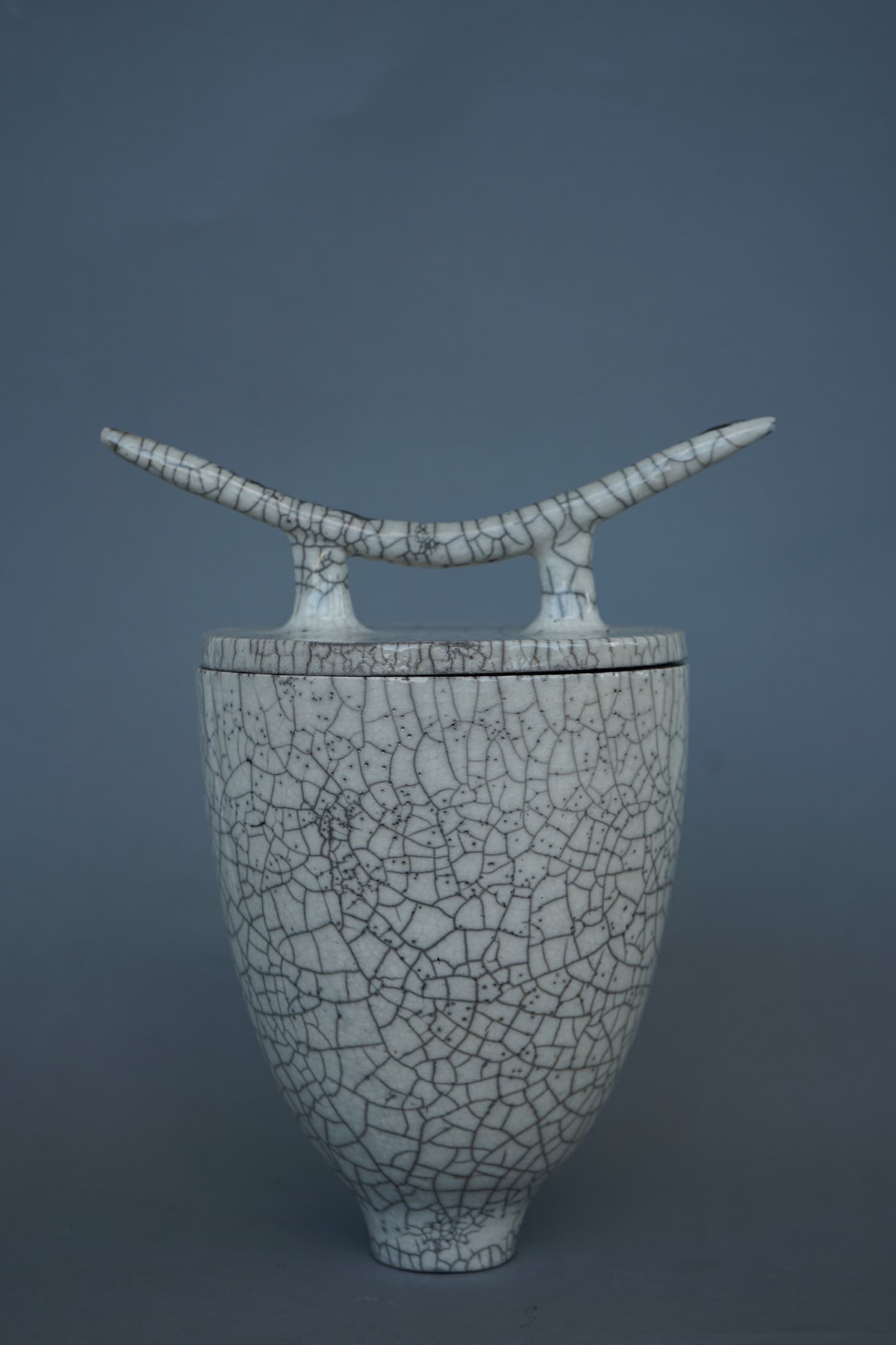 Weisse Vase mit flügelartigem Abschluss