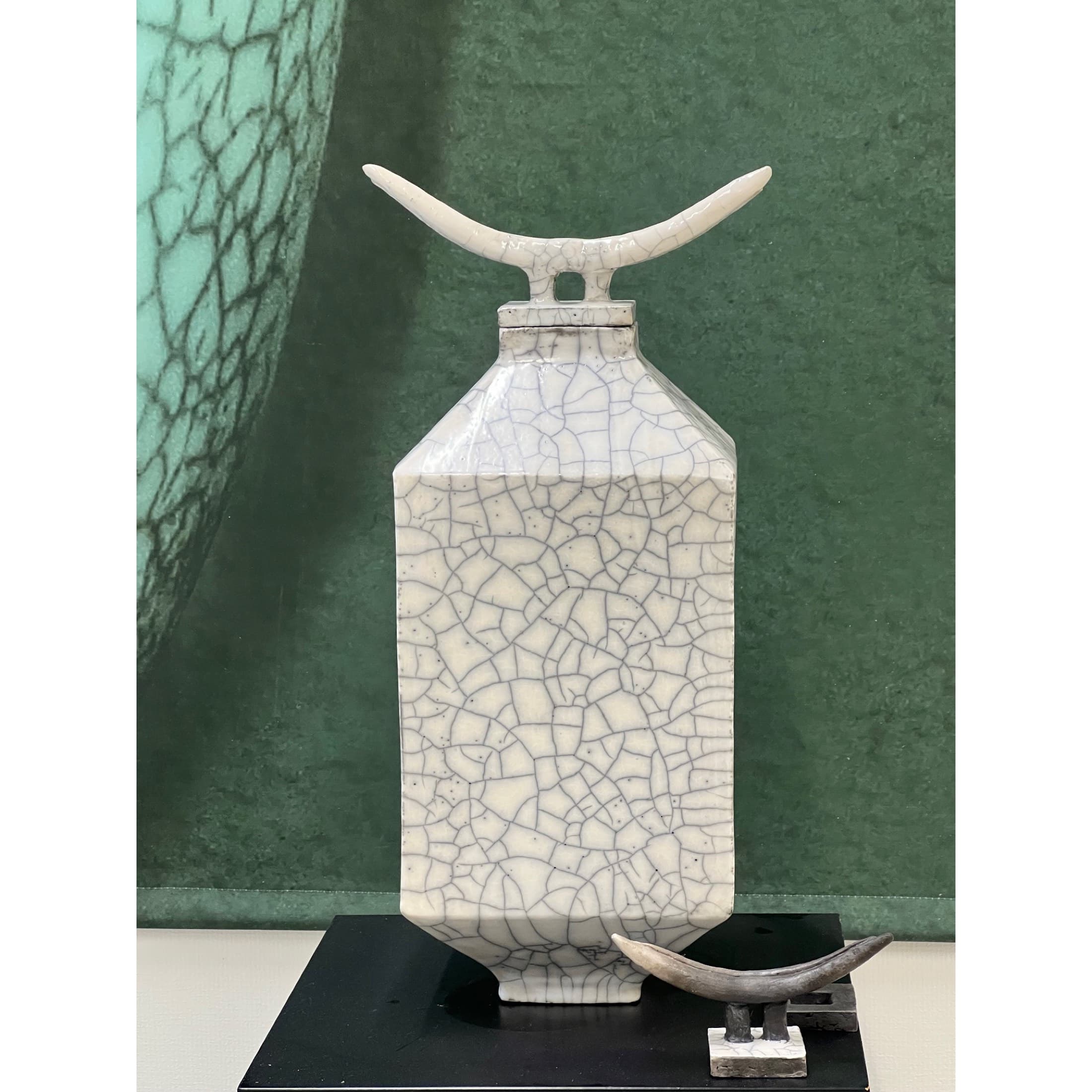 Weisse Vase vor grünem Grund