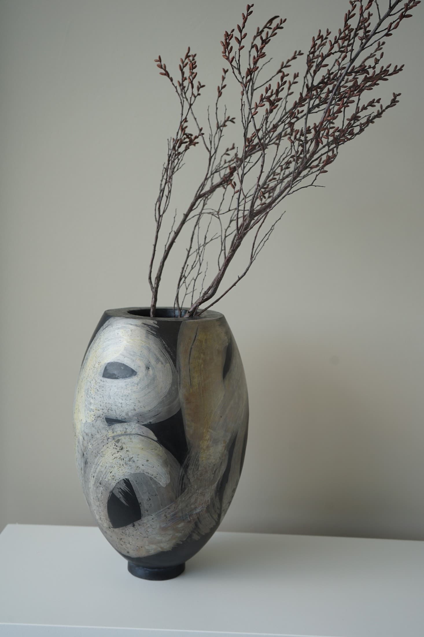Bauchige Raku-Vase mit hellen Pinselzügen und Zweigen